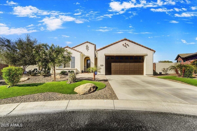 mediterranean / spanish house with a tile roof, an attached garage, driveway, and stucco siding