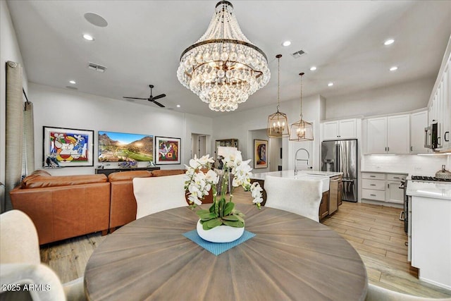 dining room featuring ceiling fan with notable chandelier, recessed lighting, light wood-style floors, and visible vents