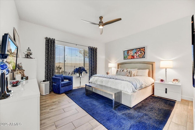 bedroom with ceiling fan, baseboards, and wood finished floors