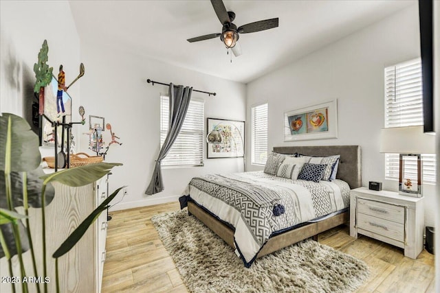 bedroom with light wood-style flooring, multiple windows, baseboards, and ceiling fan