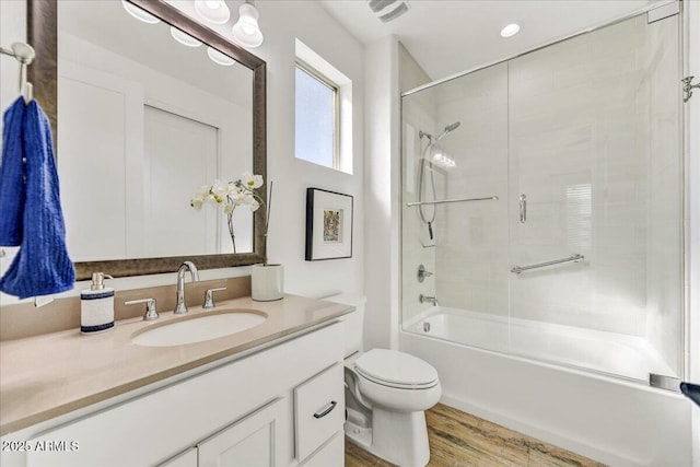 full bath featuring vanity, wood finished floors, visible vents, shower / tub combination, and toilet