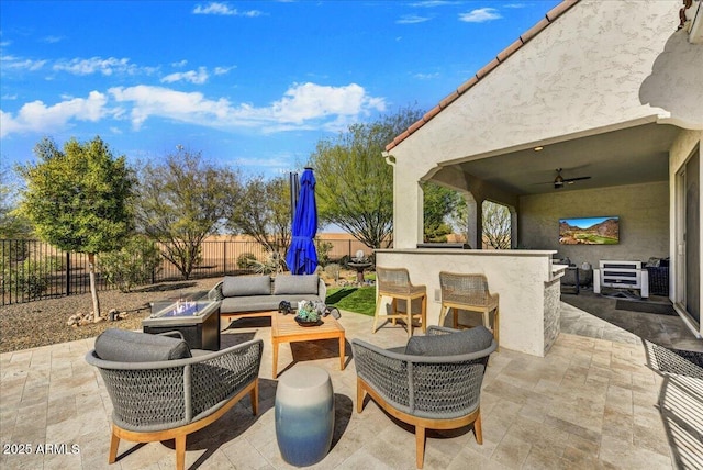 view of patio with ceiling fan, an outdoor hangout area, a fenced backyard, and outdoor dry bar