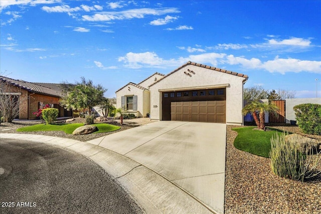 mediterranean / spanish-style home featuring a tiled roof, stucco siding, an attached garage, and driveway