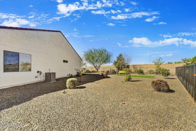 view of yard featuring central AC unit and a fenced backyard