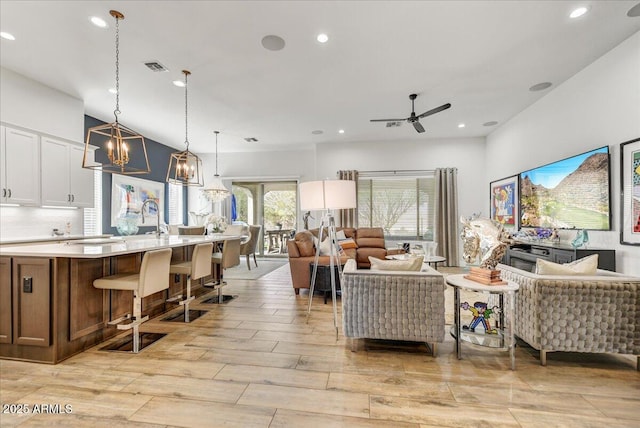 living room featuring recessed lighting, visible vents, light wood-style flooring, and ceiling fan