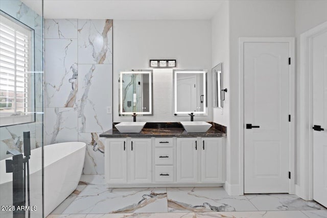 bathroom featuring vanity, a tub to relax in, and tile walls