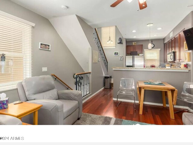 kitchen with stainless steel appliances, light stone counters, decorative backsplash, dark wood-type flooring, and decorative light fixtures