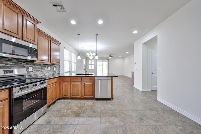 9072 W Myrtle Ave, Glendale, AZ 85305 - kitchen featuring stainless steel appliances, a peninsula, a sink, a chandelier, and brown cabinets