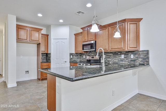 9072 W Myrtle Ave, Glendale, AZ 85305 - kitchen with stainless steel appliances, a peninsula, decorative backsplash, brown cabinetry, and decorative light fixtures