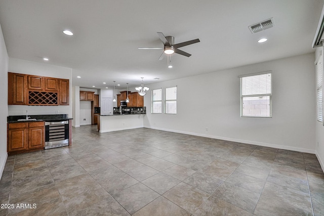 9072 W Myrtle Ave, Glendale, AZ 85305 - unfurnished living room with wine cooler, a ceiling fan, recessed lighting, a chandelier, and baseboards