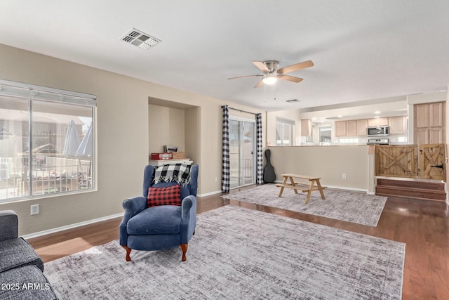 living room with a ceiling fan, baseboards, visible vents, and dark wood-style flooring