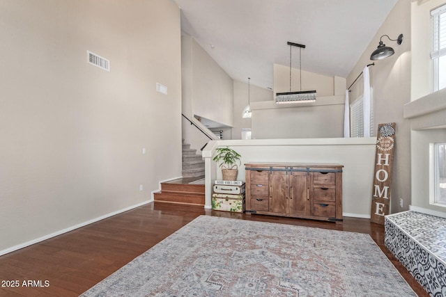 living room featuring high vaulted ceiling, visible vents, dark wood-style floors, and stairs