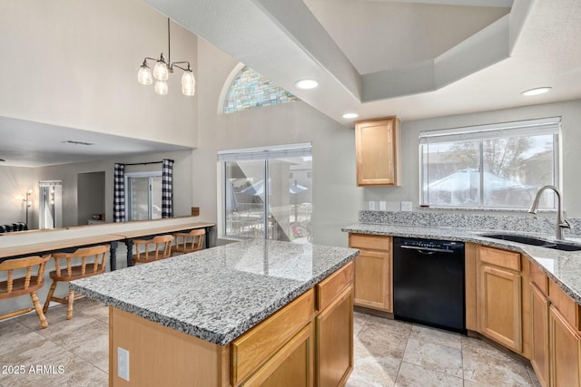 kitchen featuring black dishwasher, light stone counters, a center island, pendant lighting, and a sink