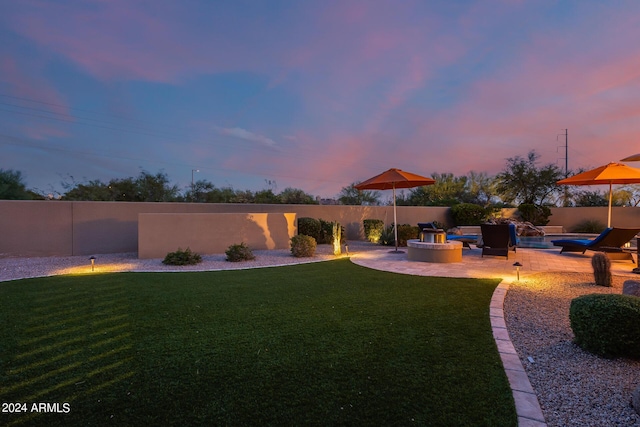 yard at dusk featuring a patio area