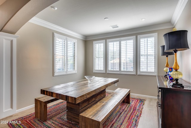 dining area featuring light wood-type flooring and ornamental molding