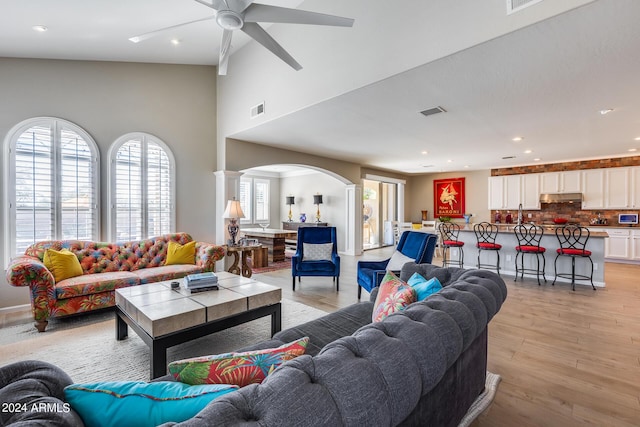 living room featuring ceiling fan, light hardwood / wood-style floors, and ornate columns