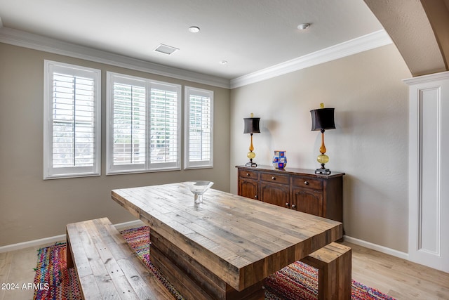 dining area with ornamental molding and light hardwood / wood-style flooring