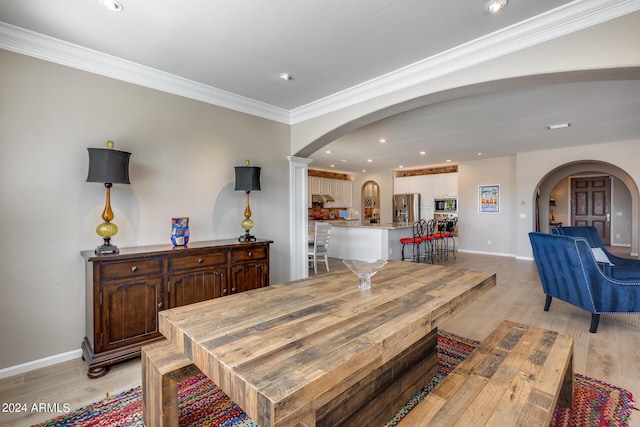 dining area featuring light wood-type flooring and ornamental molding