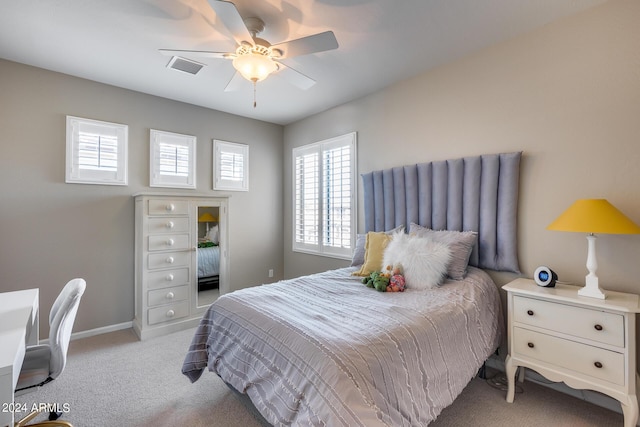 carpeted bedroom featuring multiple windows and ceiling fan