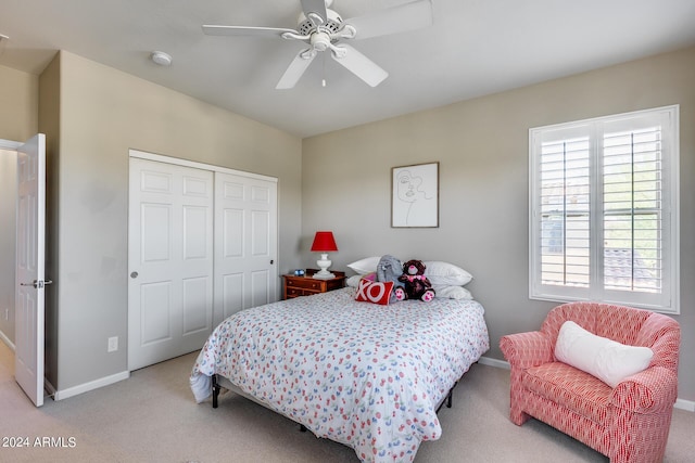 bedroom featuring multiple windows, light carpet, a closet, and ceiling fan