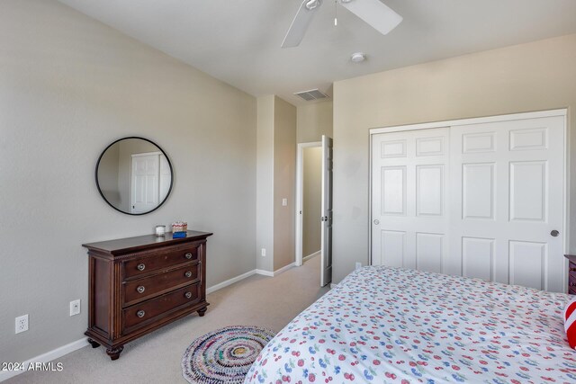 carpeted bedroom with ceiling fan and a closet