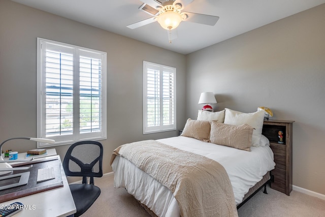 carpeted bedroom with multiple windows and ceiling fan