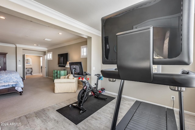 workout room with crown molding and light hardwood / wood-style flooring