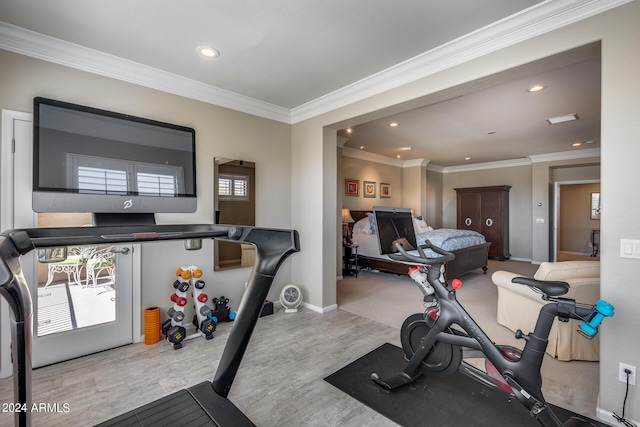 workout area with light hardwood / wood-style floors and ornamental molding