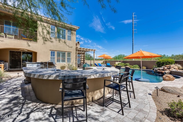 view of swimming pool featuring area for grilling, a patio area, and an outdoor bar