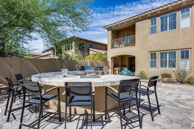 view of patio featuring exterior bar and an outdoor kitchen