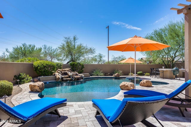 view of pool with a patio area and exterior bar