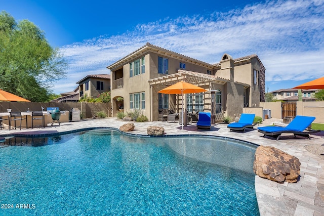 view of pool featuring a bar and a patio