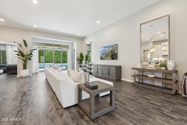 living area with baseboards, an inviting chandelier, dark wood finished floors, and recessed lighting