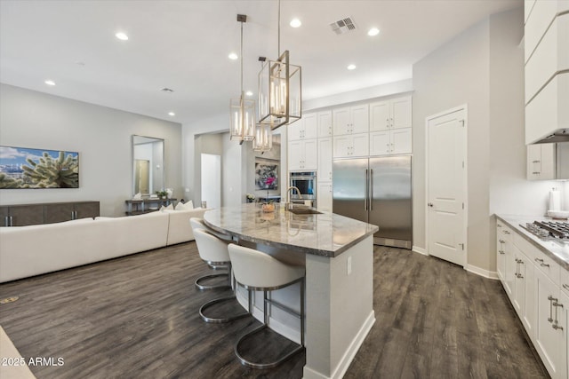 kitchen featuring white cabinetry, visible vents, appliances with stainless steel finishes, and dark wood-type flooring