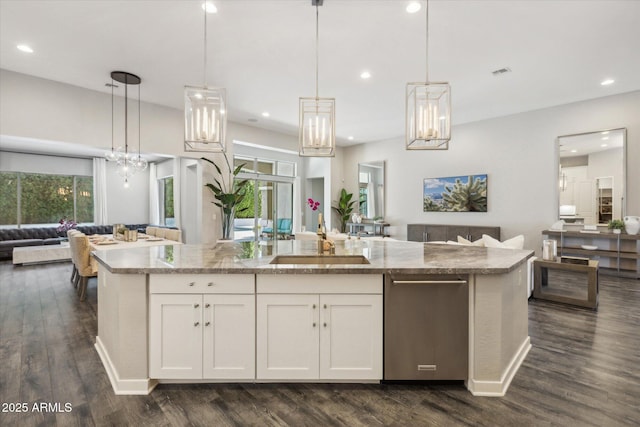 kitchen with dark wood-style floors, open floor plan, light stone countertops, a kitchen island with sink, and white cabinetry