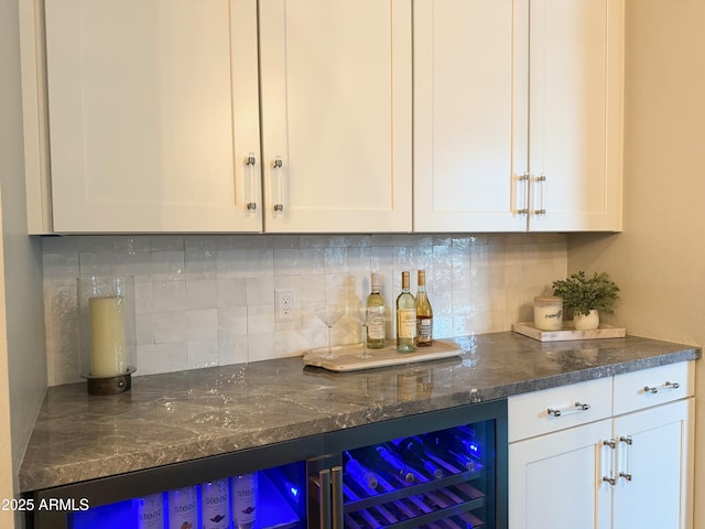 bar with tasteful backsplash, beverage cooler, and a bar