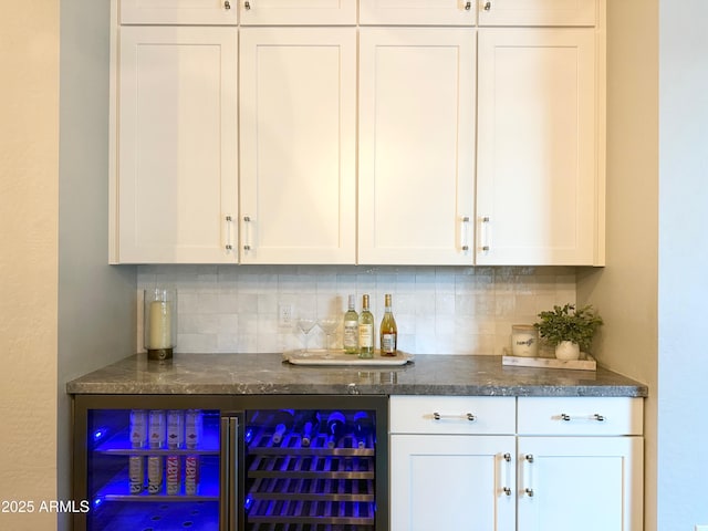 bar with beverage cooler, a bar, and tasteful backsplash