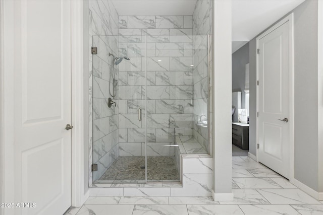 bathroom featuring marble finish floor, a shower stall, and baseboards