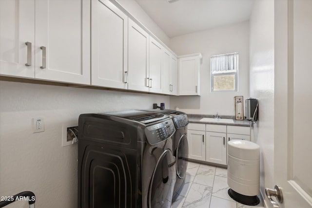 laundry area with marble finish floor, washing machine and clothes dryer, a sink, and cabinet space