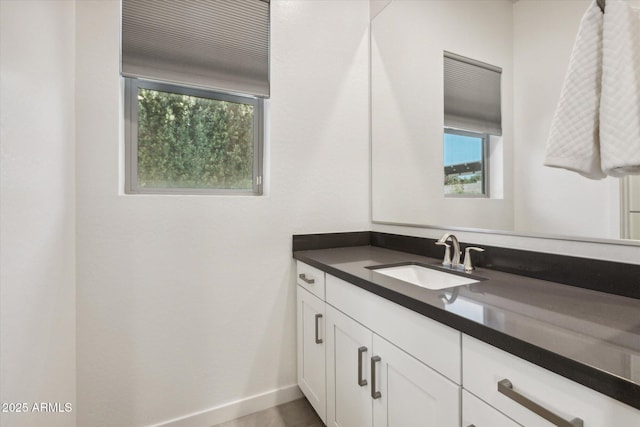 bathroom with vanity, a wealth of natural light, and baseboards