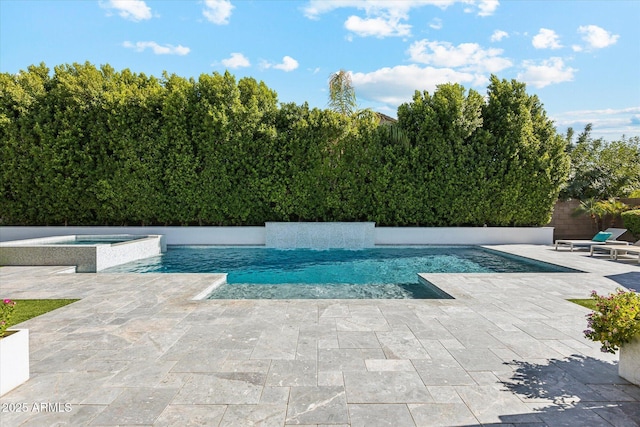 view of pool with a patio area and a pool with connected hot tub