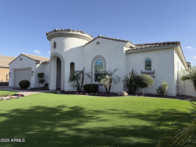 mediterranean / spanish home featuring a garage, a front yard, a tile roof, and stucco siding