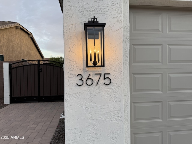 exterior details with a gate and stucco siding