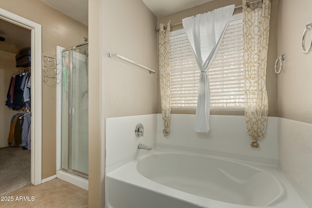 41811 W Avella Dr, Maricopa, AZ 85138 - bathroom with a stall shower, tile patterned floors, a bath, and a spacious closet