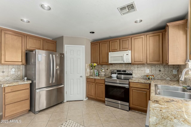 41811 W Avella Dr, Maricopa, AZ 85138 - kitchen with light tile patterned flooring, backsplash, a sink, stainless steel appliances, and visible vents