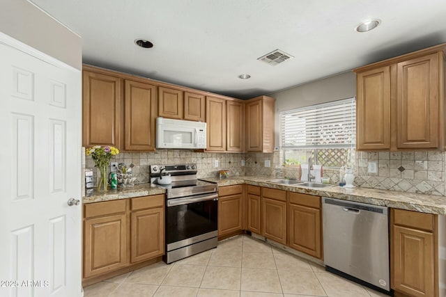 41811 W Avella Dr, Maricopa, AZ 85138 - kitchen featuring decorative backsplash, a sink, light tile patterned flooring, visible vents, and appliances with stainless steel finishes