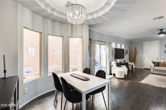 dining space with ornamental molding, dark hardwood / wood-style floors, a raised ceiling, and ceiling fan with notable chandelier