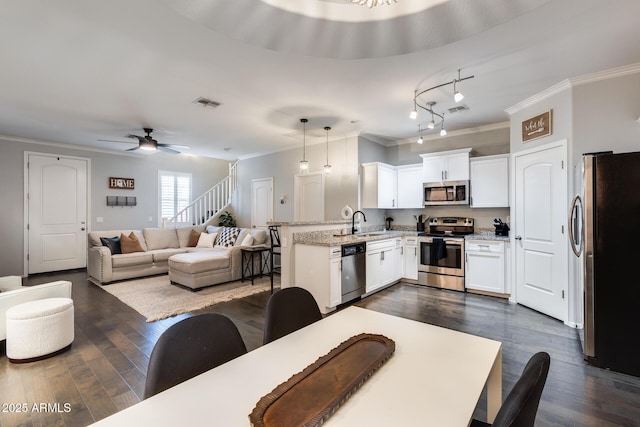 kitchen with white cabinetry, decorative light fixtures, kitchen peninsula, and appliances with stainless steel finishes