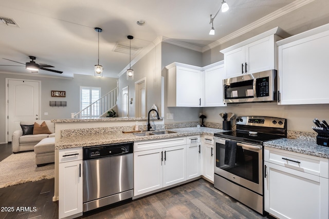 kitchen featuring appliances with stainless steel finishes, sink, white cabinets, and kitchen peninsula