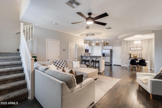 living room with dark wood-type flooring, ceiling fan, and crown molding